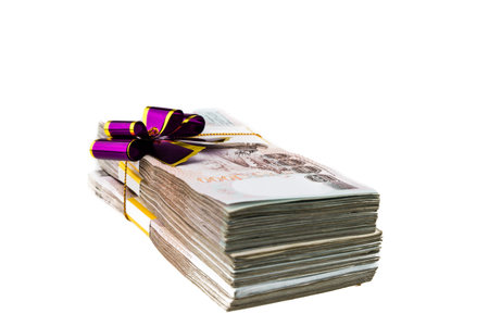 Thailand money banknotes stacked wrapping with purple bow isolated.の写真素材