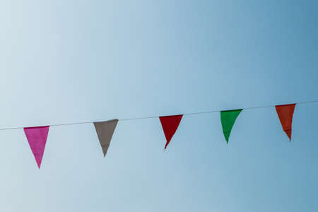 Multi Colored Triangular Flags Hanging in the Sky.の写真素材