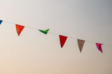 Multi Colored Triangular Flags Hanging in the Sky.の写真素材