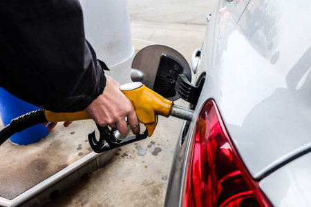 Hand refilling the car with fuel