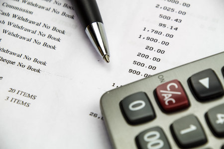 Pen point on bank statement with calculator