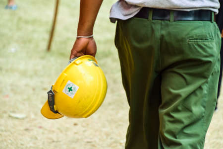 worker carry yellow engineer hat on hand.の写真素材