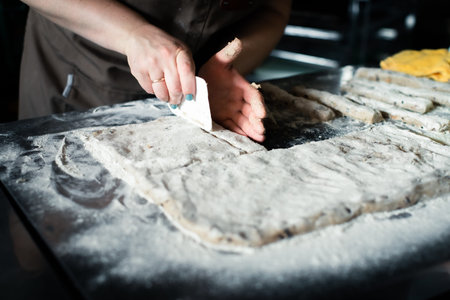 Molding rye sticks with chocolate and hazelnuts by a woman