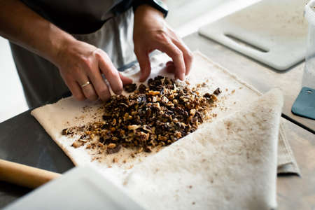 Baker prepares nuts in doughの写真素材