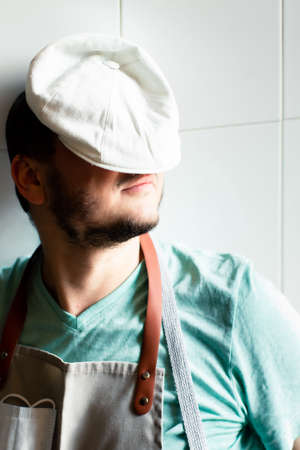 A young baker in a cap and apron sleeps on a work in a bakery. Fatigue concept.の写真素材