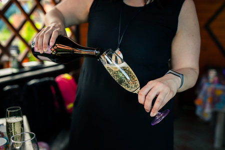 A woman pours champagne into a glass at a house party