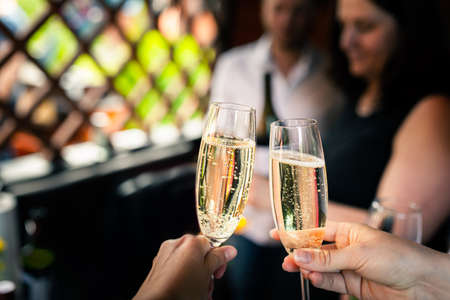 Friends raise glasses of champagne at a partyの写真素材