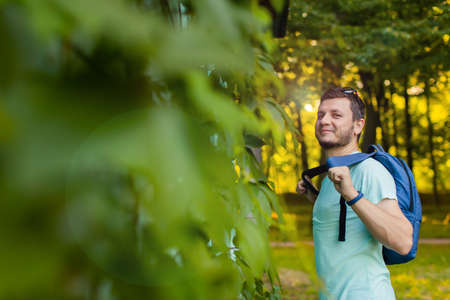 A young man in the park with a backpackの写真素材