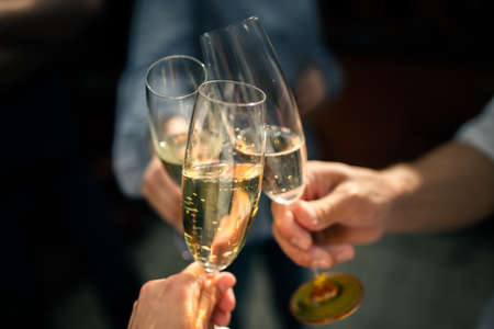 Friends raise glasses of champagne at a partyの写真素材