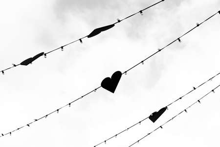 A garland of hearts stretched in the sky, black and white photo.の写真素材