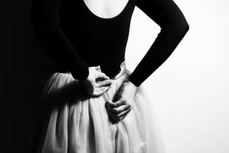 The ballerina prepares for the performance, fastens the ballet tutu. Black and white photo. Photo from the back.の写真素材