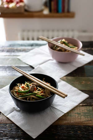 Ramen with beef and egg noodles in bowls on a wooden backgroundの写真素材