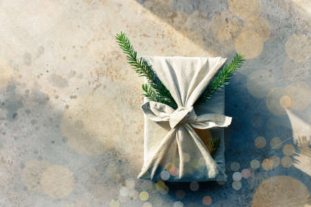 Furoshiki style gift for Christmas or New Year on a white background with bokeh. Flat lay. Copy space.の写真素材