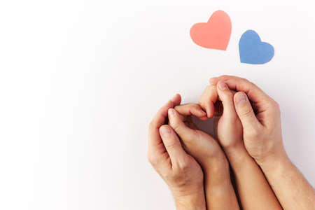 Valentines Day, hearts blue and red made of paper are near the hands of a couple in love. Top view. Copy space. Place for text.の写真素材