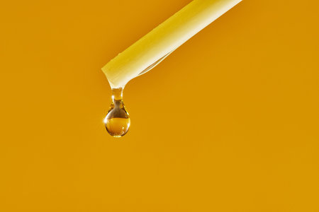A drop of aromatic oil drips from the incense stick of the diffuser. Front view. Macro photo.