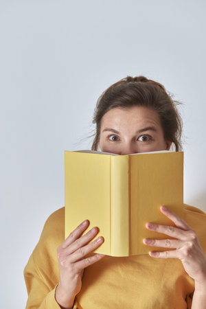 A beautiful, mysterious woman with a yellow book. Front view.