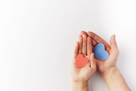 Valentines Day, hearts blue and red made of paper are held in the hands of a couple in love. Top...