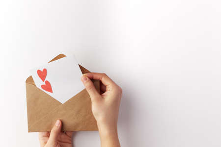 Valentines Day, a note in a paper heart envelope. Top view. Copy space. Place for text.の写真素材