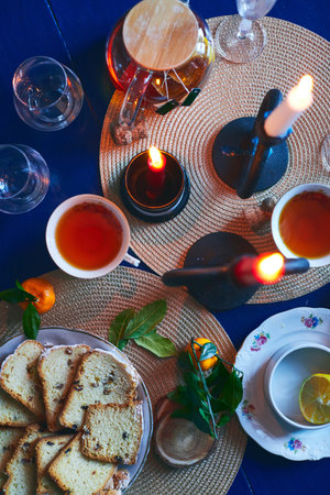 Festive still life of tea, cake, tangerines and candles. Christmas Eve and New Years Eve. Flat lay.の写真素材