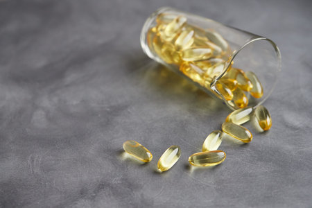 Capsules of omega-3 fatty acids on a gray background. The concept of medicine and a healthy...