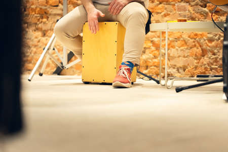 A man plays the cajon, a percussion instrument. Concert, view from the lowest point. Copy space.の写真素材