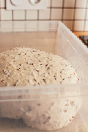 Making homemade wheat bread with flax seeds. The dough rinsing. The concept of homemade bread and healthy food. Vertical photo.の写真素材