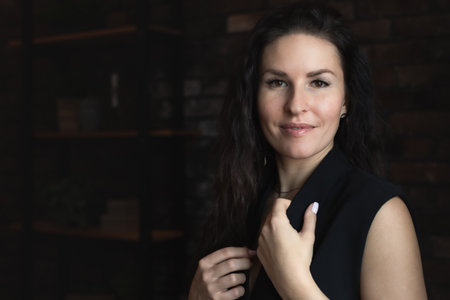 Portrait of an attractive woman on a dark background in a strict suit. Front view.の写真素材