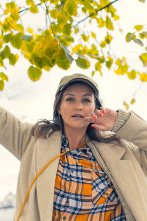 Portrait of a young attractive woman, hello autumn, the beginning of the season. Vertical photo.の写真素材