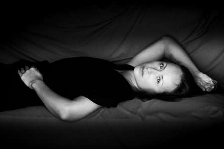 Black and white photo of an attractive woman. A large portrait on a dark background. Front view.の写真素材