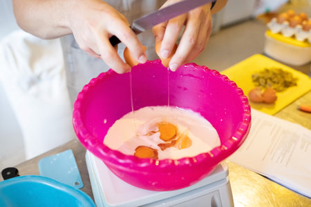 The process of making artisan bread. Adding eggs to milk for muffin dough. Front view.