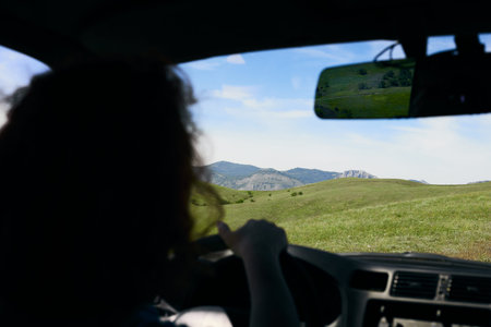 A panorama of beautiful green hills. A summer landscape in the Crimea. View from a car, driven by a...