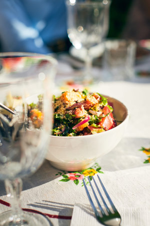 A bowl of snacks on the table. Vegetables and grits in a salad. Vertical photo.