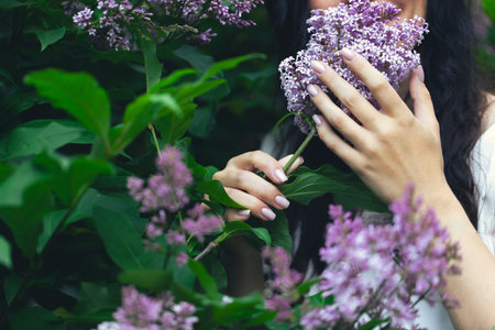 Hands of an attractive woman with a bouquet of lilacs. Spring and summer, seasonal photos. Front...