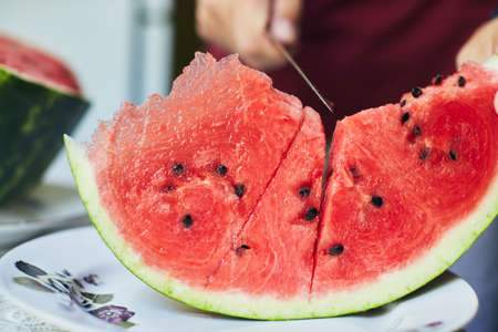 Juicy red watermelon is cut with a knife. The concept of summer and delicious vegetables. Front view.の写真素材