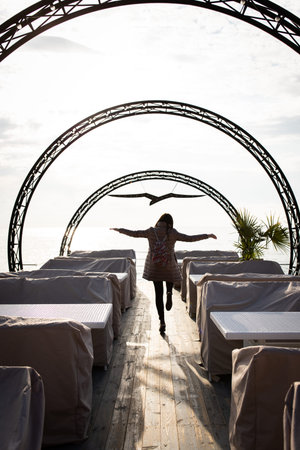 A woman runs to the sea in winter along the arches. The seagull symbol at the end of the tunnel....