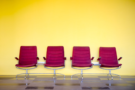 red chairs against yellow wallの写真素材