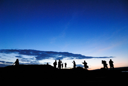silhouette of photographer taking picture of landscape during sunriseの写真素材