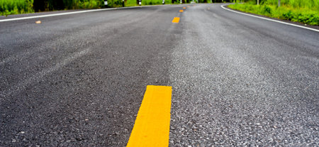 Close up asphalt surface of road divide yellow lines