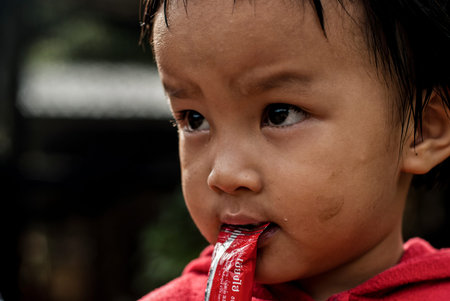 CHIANG MAI THAILAND - OCTOBER 23 : unidentified children eat snacks in their village on OCTOBER 23, 2009 in CHIANG MAI, THAILANDのeditorial素材
