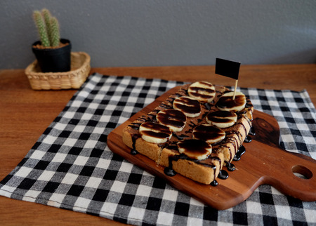 Toast topped with sliced bananas, nuts, chocolate and caramel syrupの写真素材