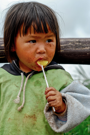 PHETCHABUN THAILAND - JUNE 24 : Unidentified little girl eating a lollipop on the mountain Phu Thap Boek JUNE 24, 2007 in PHETCHABUN THAILANDのeditorial素材