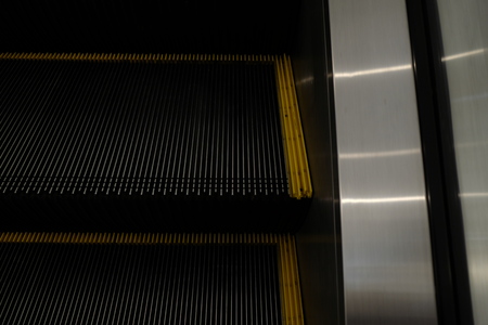 abstract escalator in shopping mall, Moving up staircase, yellow bands. metal line steelの写真素材