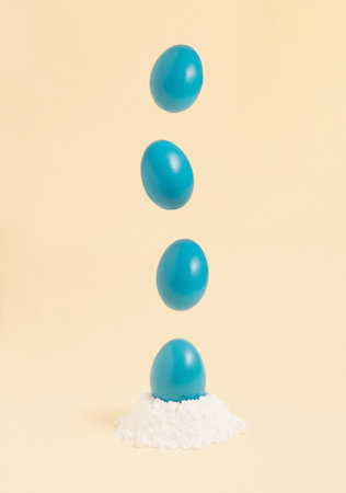Blue Easter eggs hover above the egg source. Pastel background colors. Creative composition.