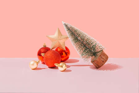 On a pink pastel background, a glass with a red ornament in it. Minimal creative idea. New Year 2022の写真素材
