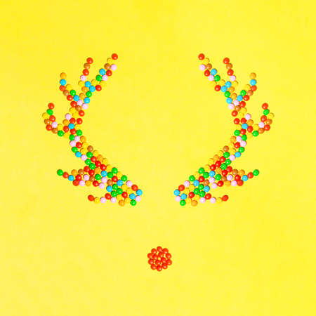 Reindeer horns made of candy for children. Minimal creative composition. Flat lay. Yellow background. Holiday spells.の写真素材