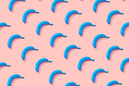 Pastel color pattern. Blue bananas lined up on a pink background. Creative idea.の写真素材
