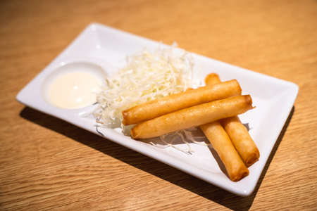 Ebi Roll (Raw Shrimp Spring Roll) placed on white dish with shredded cabbageの写真素材