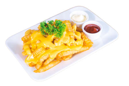 French fries topped with cheese, served with tomato sauce and mayonnaise on a white plate, isolated white background.の写真素材