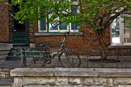 bike sitting against a railing in front of a brick resident in Montreal Canadaの写真素材