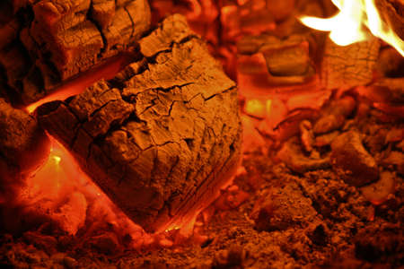 red hot coals glowing inside a wood stoveの写真素材